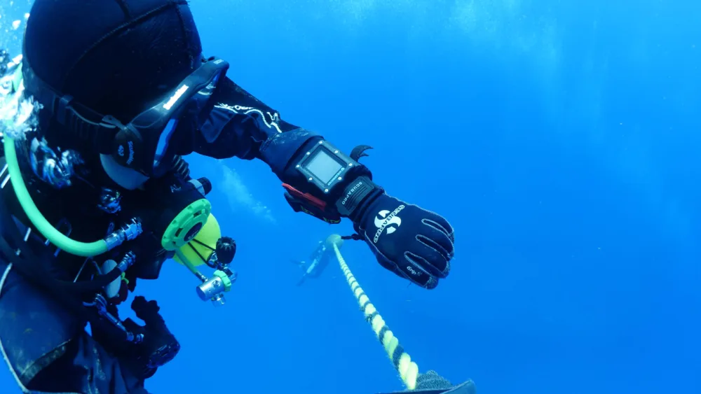 Scuba diver looking at computer showing gradient factors for scuba diving.